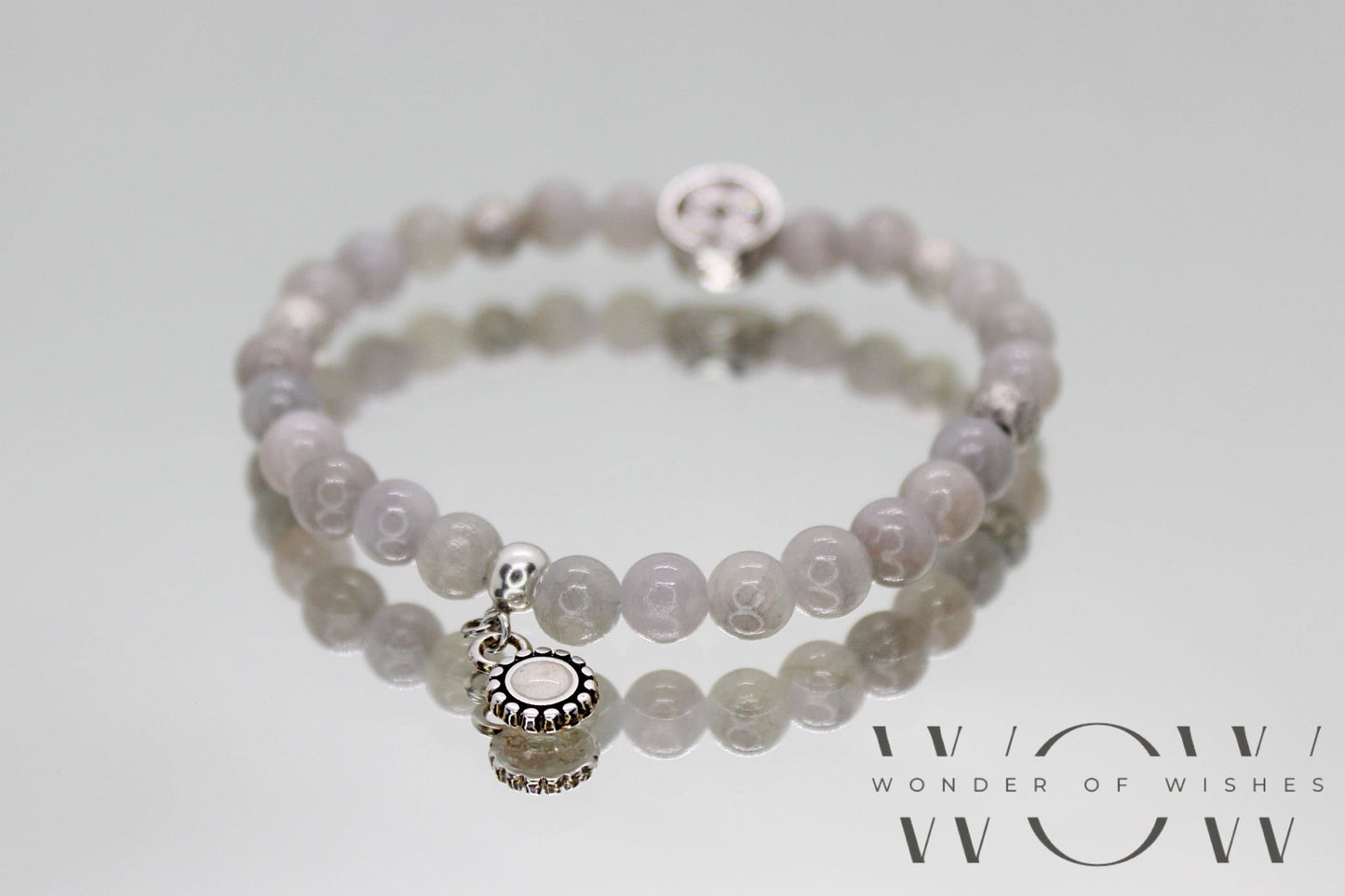 Ein graues 6 mm perlenarmband aus natursteinen mit silberne nickelfreie Zwischenteile inkl. Anhänger